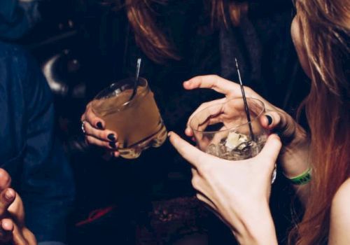 A group of people enjoying drinks and laughing together, capturing a lively and social moment.