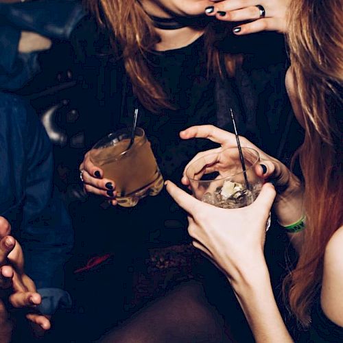 A group of people enjoying drinks and laughing together, capturing a lively and social moment.