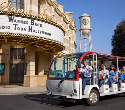A tour bus in front of a building with a sign and water tower.