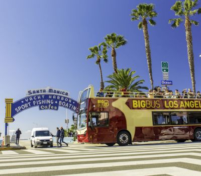 a bus stopped at a crosswalk in front of an archway